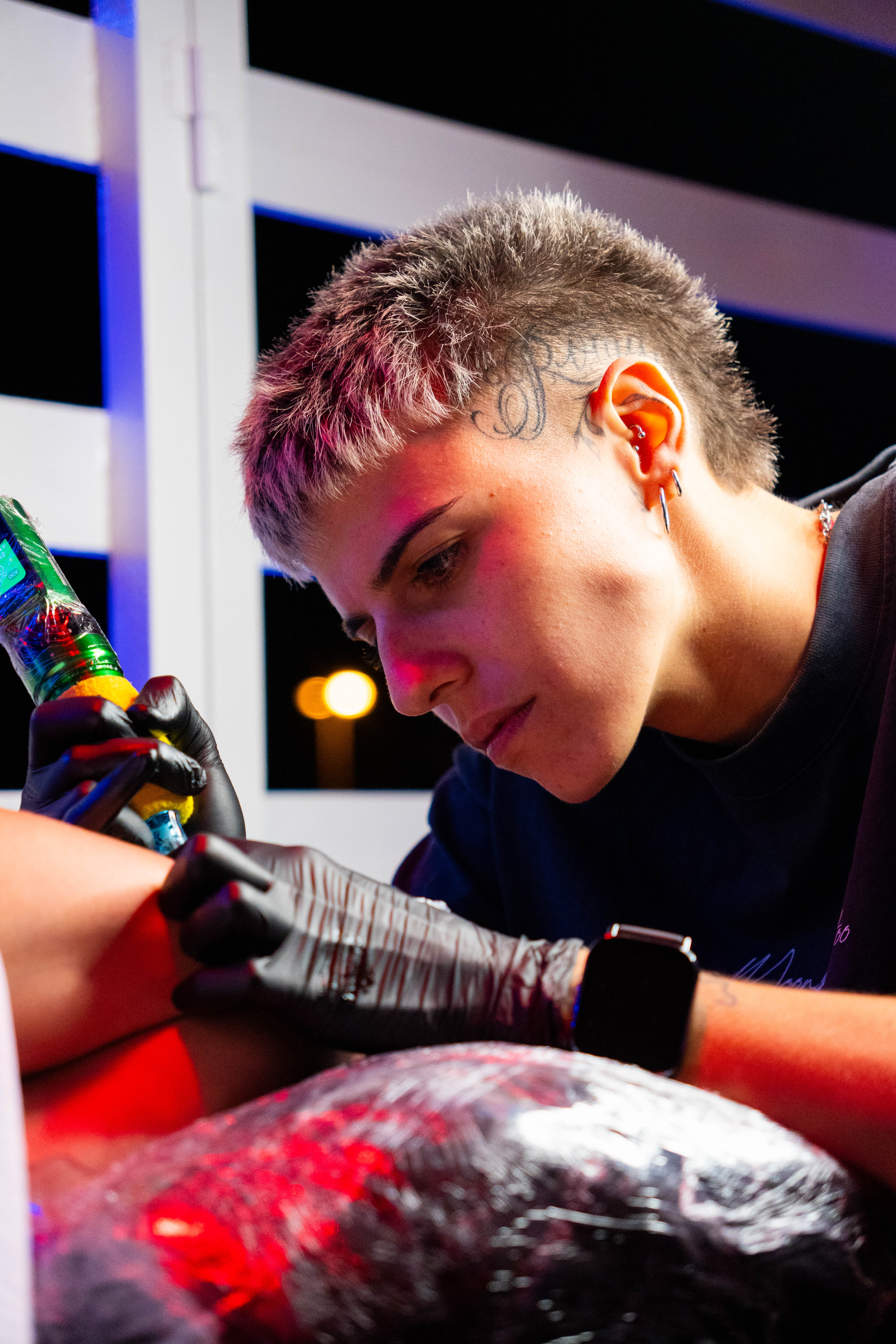 Tatuador trabajando durante un evento nocturno